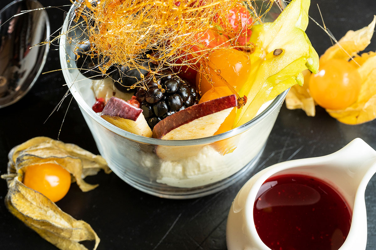 Piatto dal menu Pisco: yogurt con frutta, caramello e concentrato di lampone